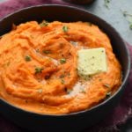 Pat of butter melting into a bowl of mashed sweet potatoes.