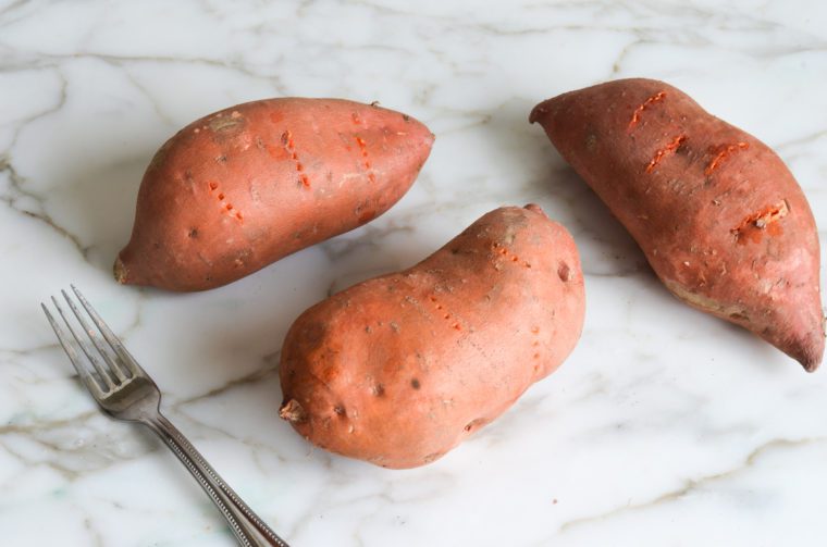 pricking the sweet potatoes with a fork