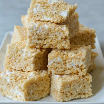 Rice Krispie treats stacked on platter from the best Rice Krispie treat recipe.