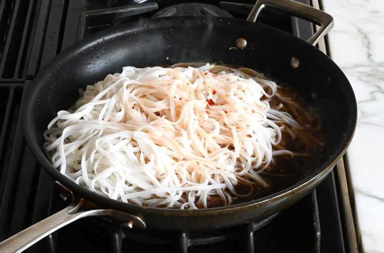 cooking the rice noodles in the sauce