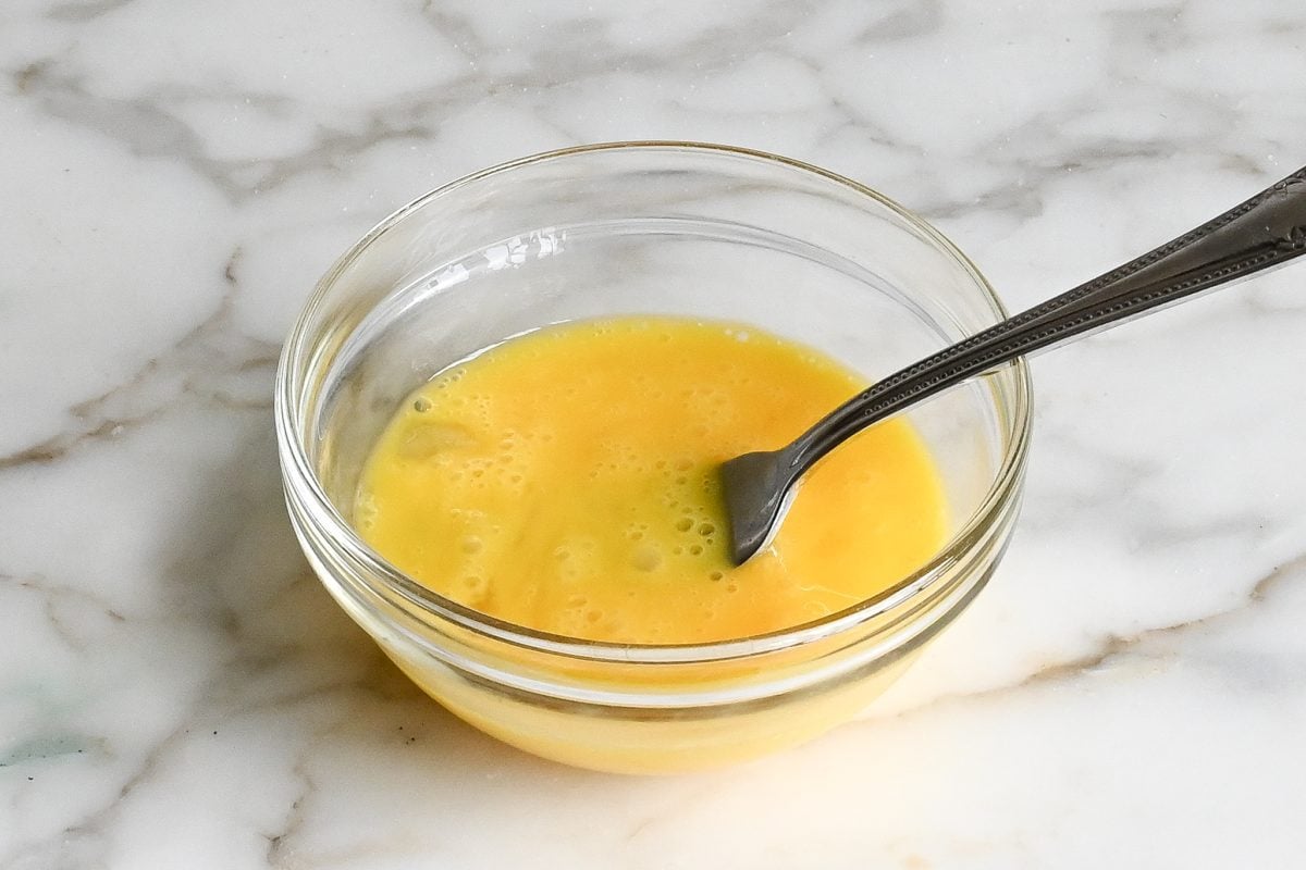 Fork in a bowl with beaten eggs.