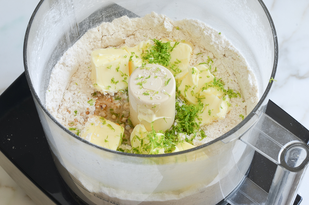 adding butter, lime zest and vanilla to food processor