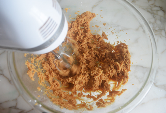 Electric mixer in a bowl with a peanut butter mixture.