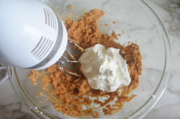 Whipped cream in a bowl of peanut butter mixture.