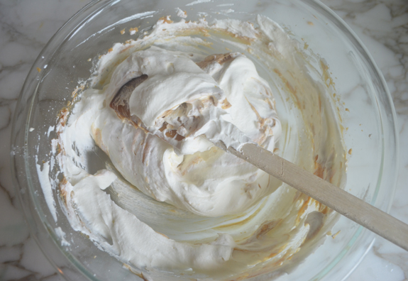 Spatula folding whipped cream into a peanut butter mixture.