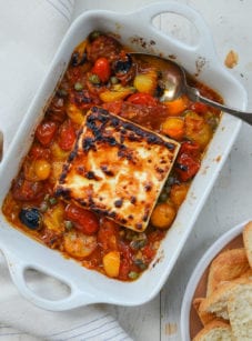 Baking dish of broiled feta with garlicky tomatoes and capers.