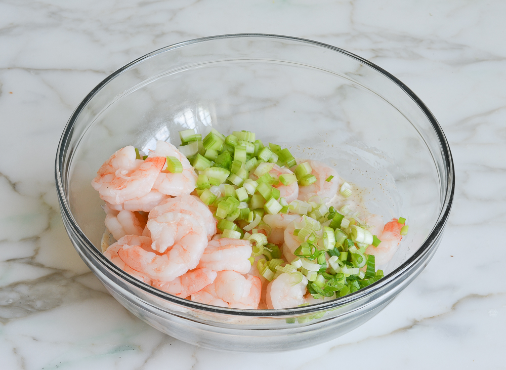 adding the shrimp, celery and scallions to the dressing