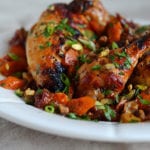Plate of sweet and spicy roast chicken with carrots, dates, and pistachios.