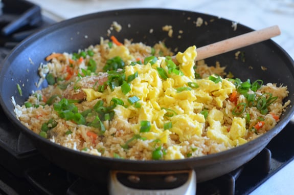 Scrambled eggs in a skillet with riced cauliflower.