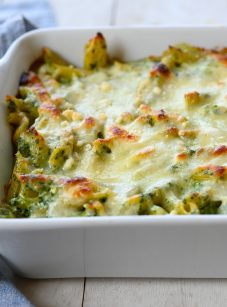 Penne with spinach, ricotta, and fontina in a baking dish.