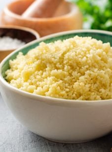 steamed couscous in bowl with plaid linen napkin.