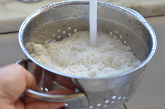 draining rice noodles for thai chicken soup