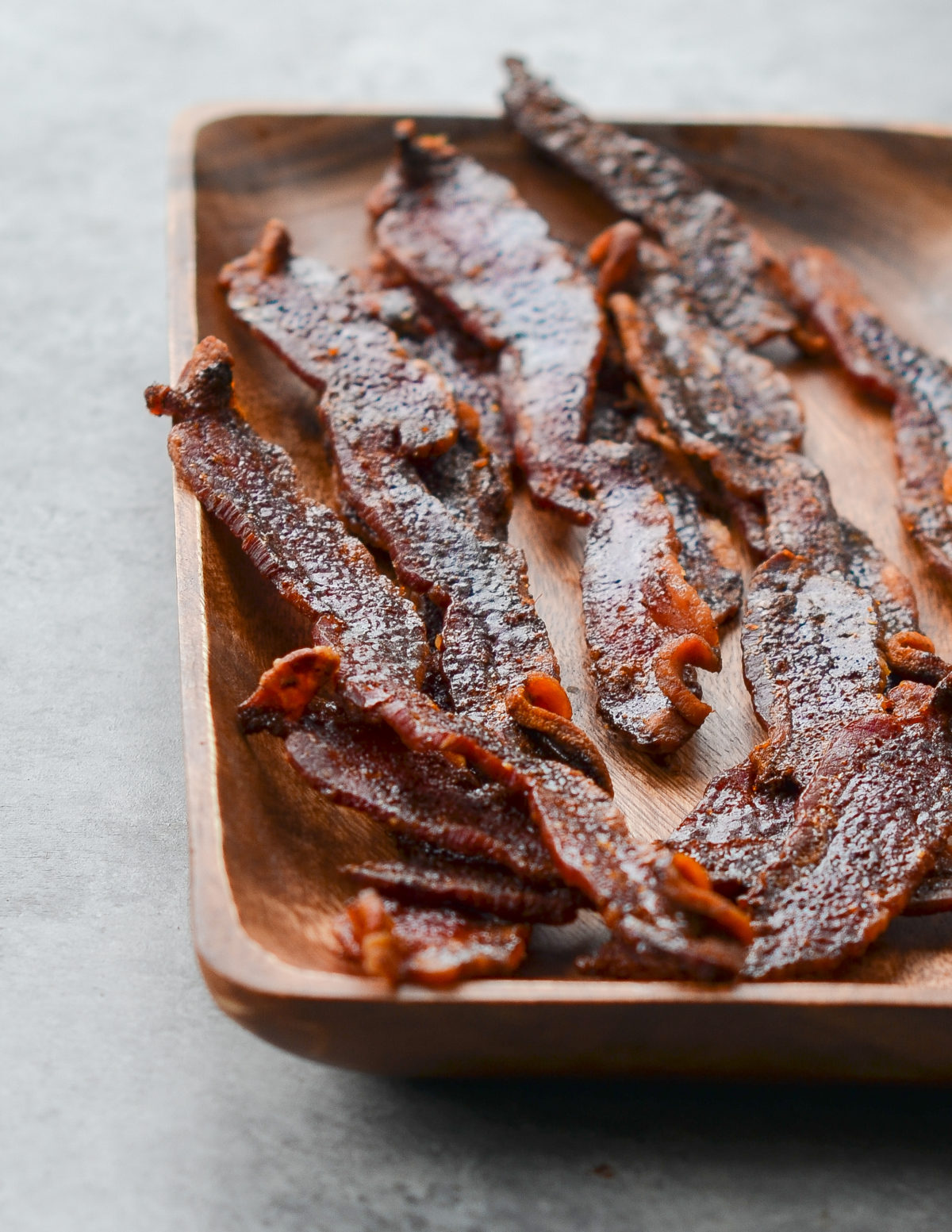 Wooden plate of candied bacon.