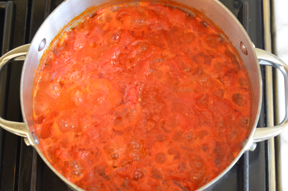 Pan of simmering, crushed tomatoes.