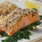 Baked salmon with honey mustard and pecan-panko crust on a plate with a fork.