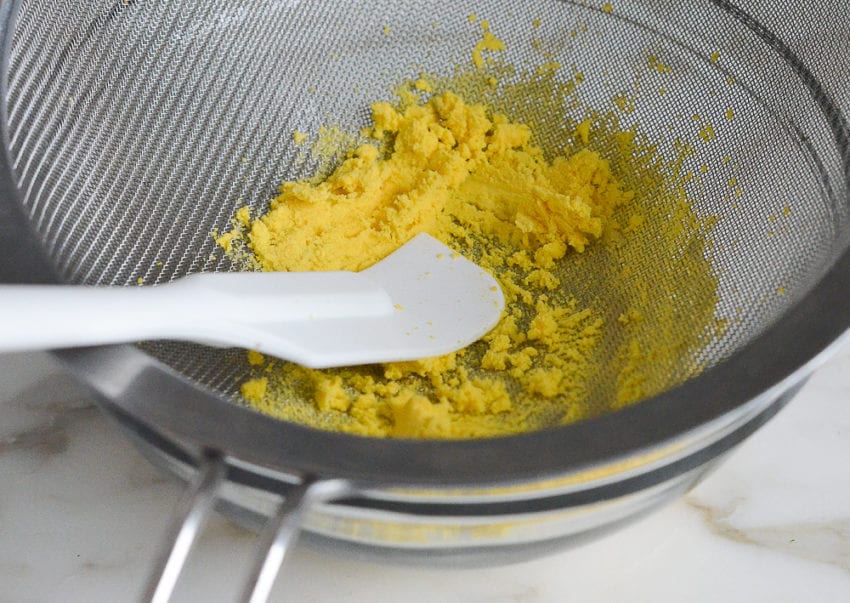 mashing the yolks through a fine sieve