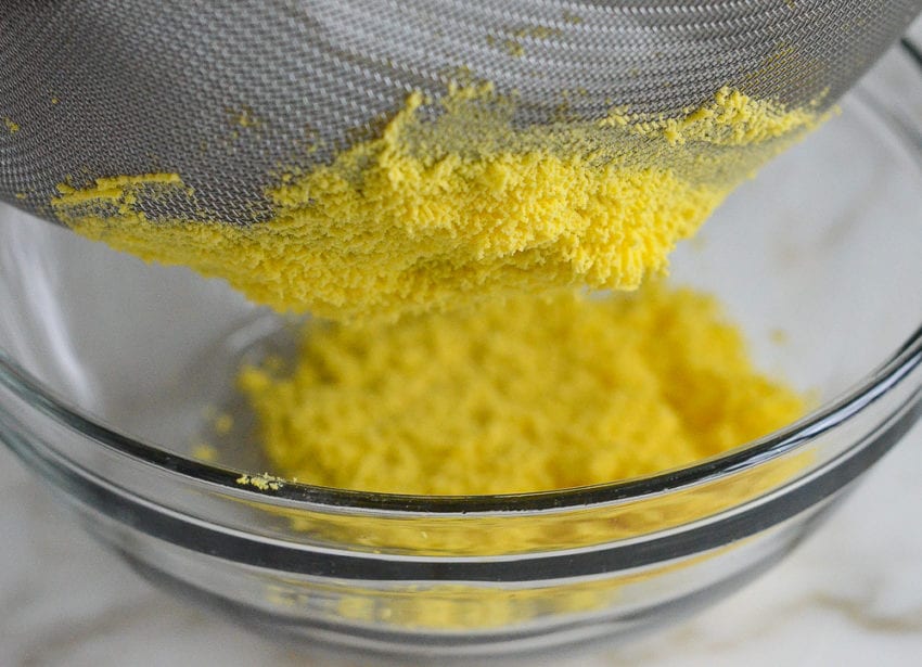 mashing yolks though sieve