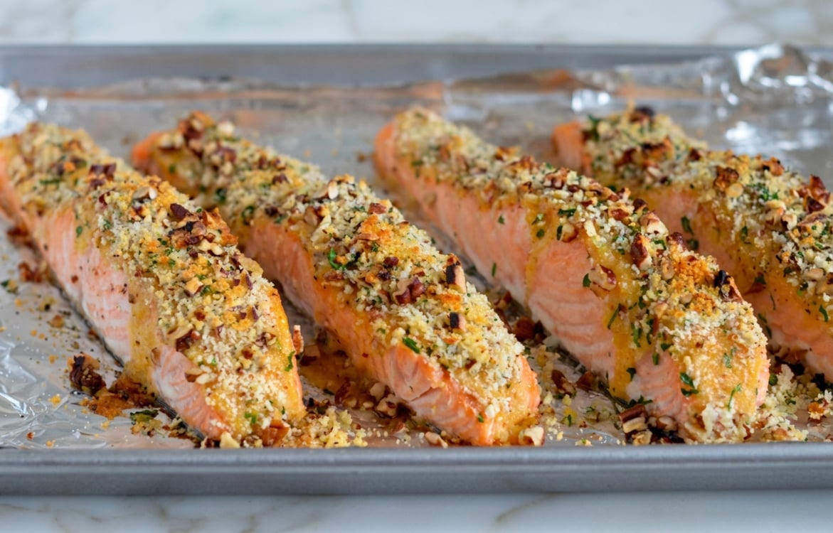 Baked pecan crusted salmon on baking sheet.