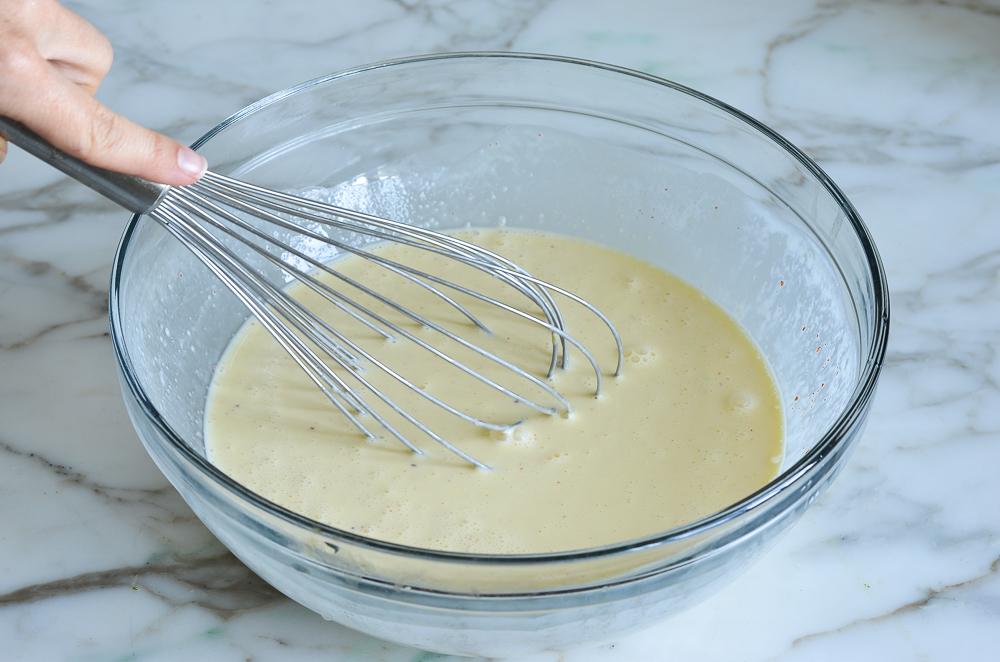 Whisk in a bowl of egg and cream mixture.