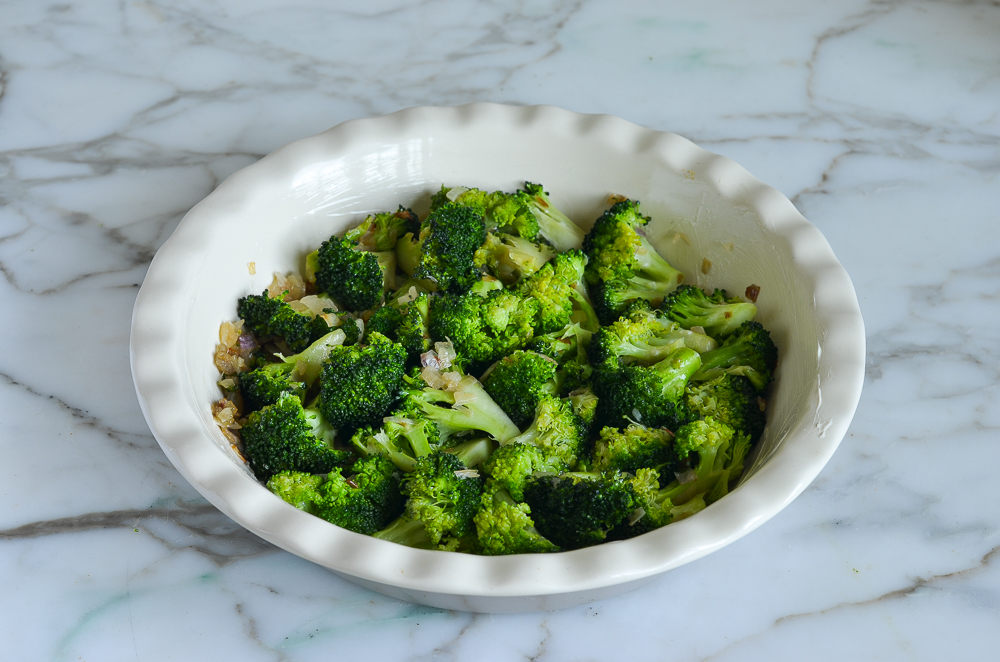 Broccoli and shallots in a pie pan.