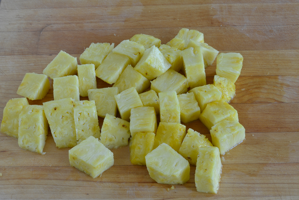 Pineapple chunks on a cutting board.