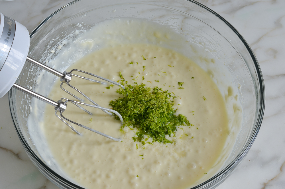 Lime zest in a bowl with an electric mixer.