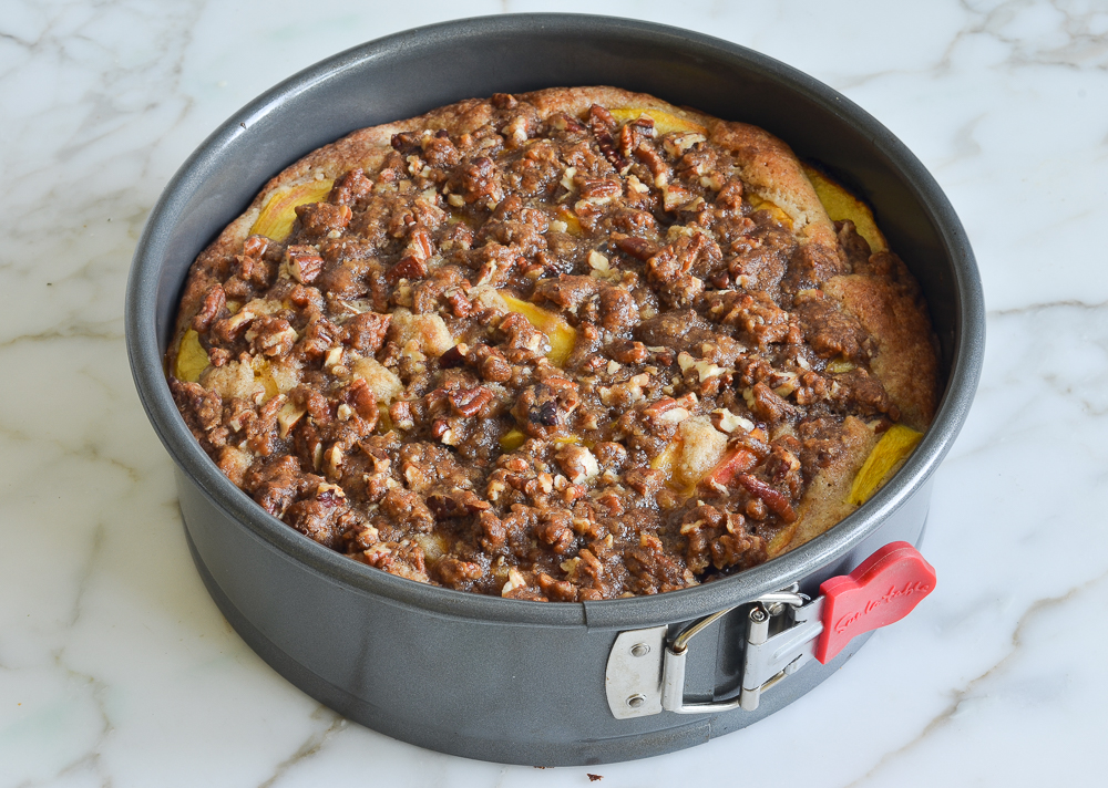 Peach cake with pecan streusel in a springform pan.