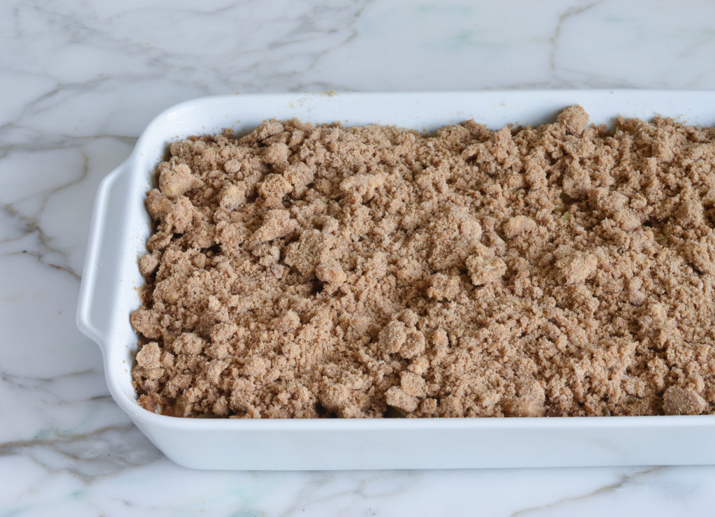 Streusel topping over noodles in a baking dish.