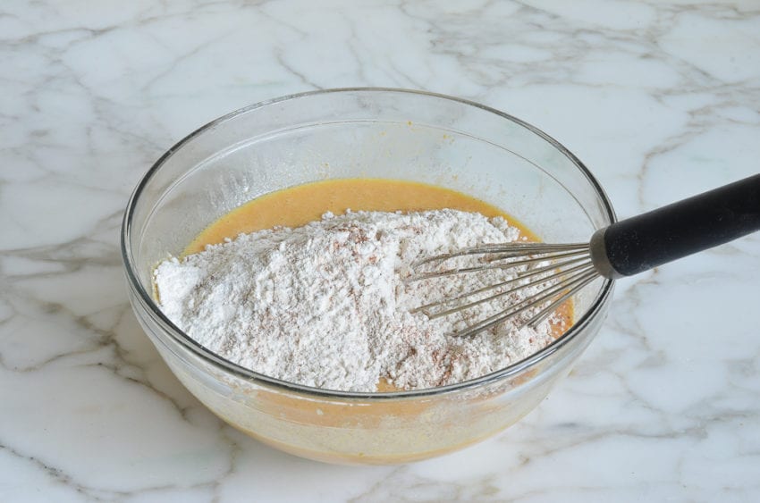 adding dry ingredients to wet pumpkin mixture