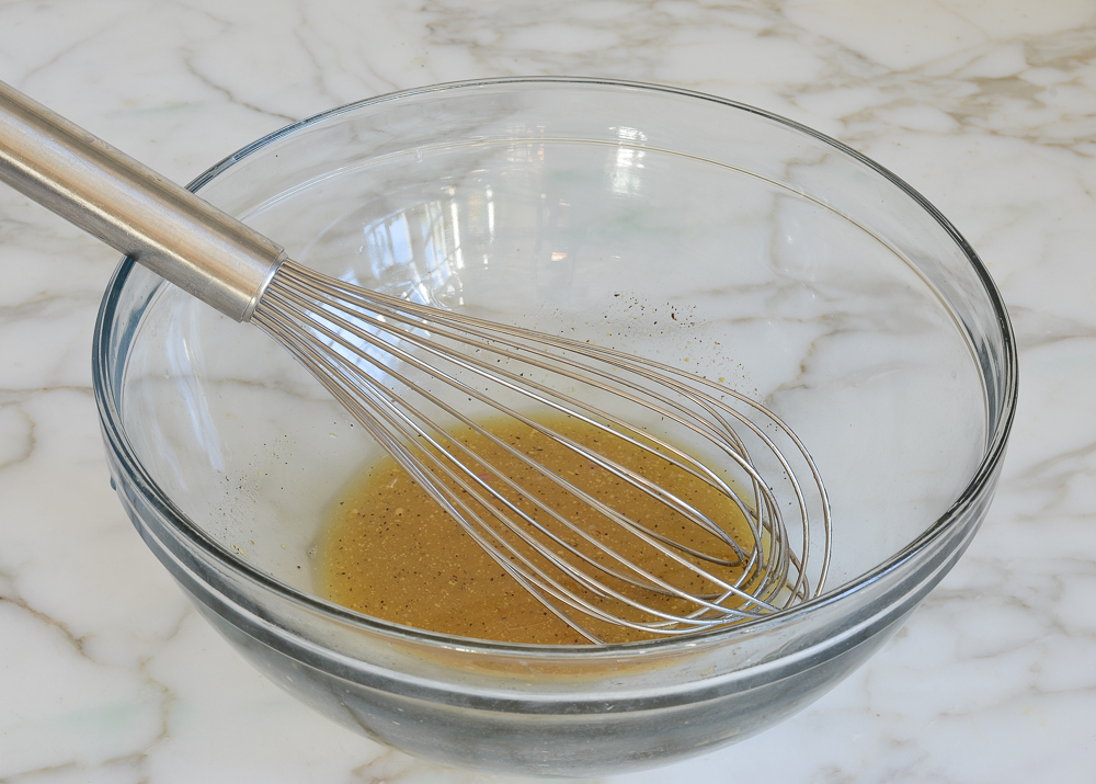 Whisk in a bowl with a vinegar and honey mixture.