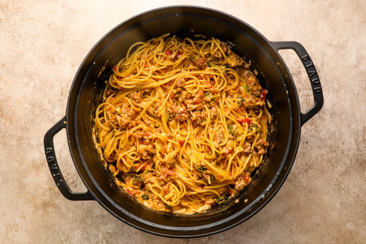 dutch oven with spaghetti, egg mixture, sausage-broccoli combo, cheddar, fontina, and Parmesan mixed together