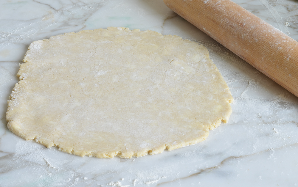 Rolling pin with a circle of dough.