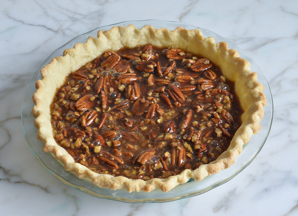 Pie crust filled with an unbaked brown butter and bourbon pecan filling.