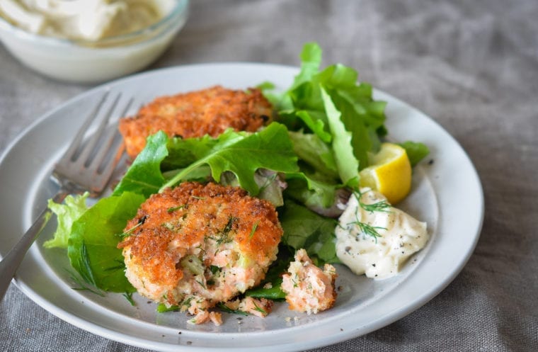 two salmon cakes on plate with tartar sauce