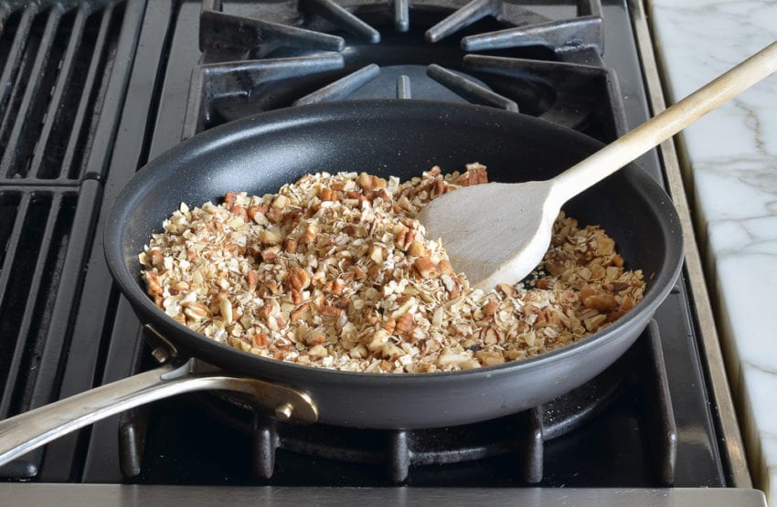 Oats and nuts in a skillet.