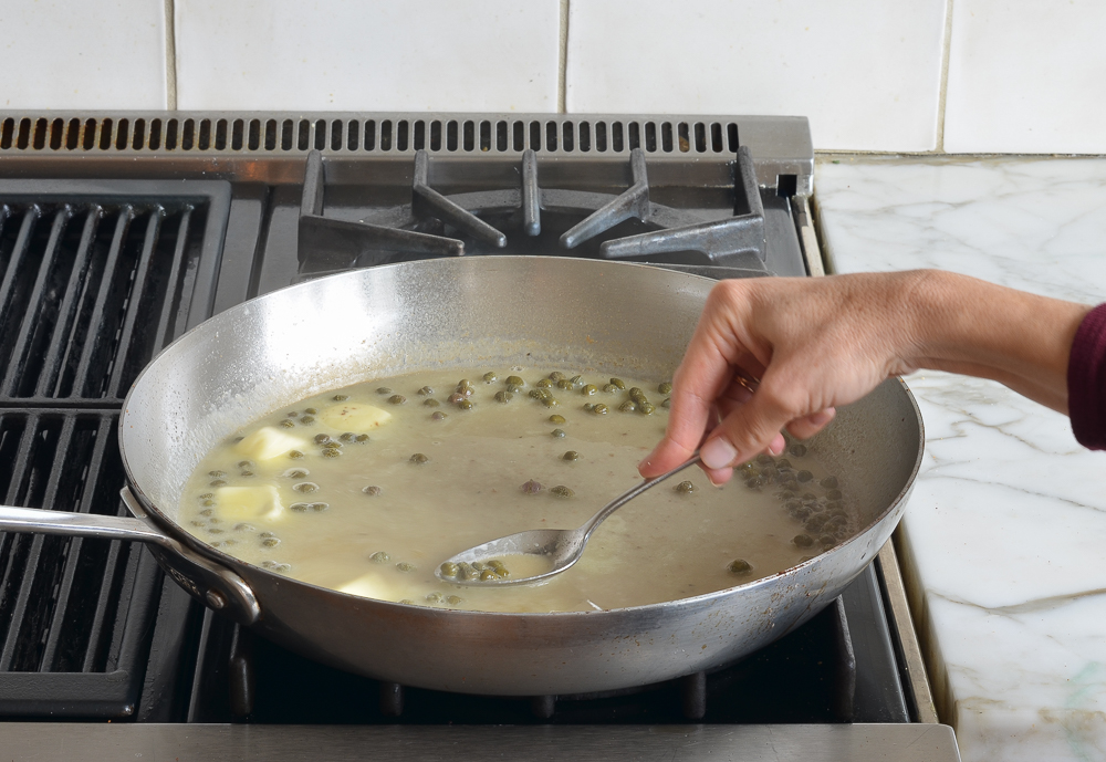 swirling butter into the chicken piccata sauce