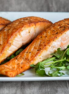 Salmon on a plate with greens.