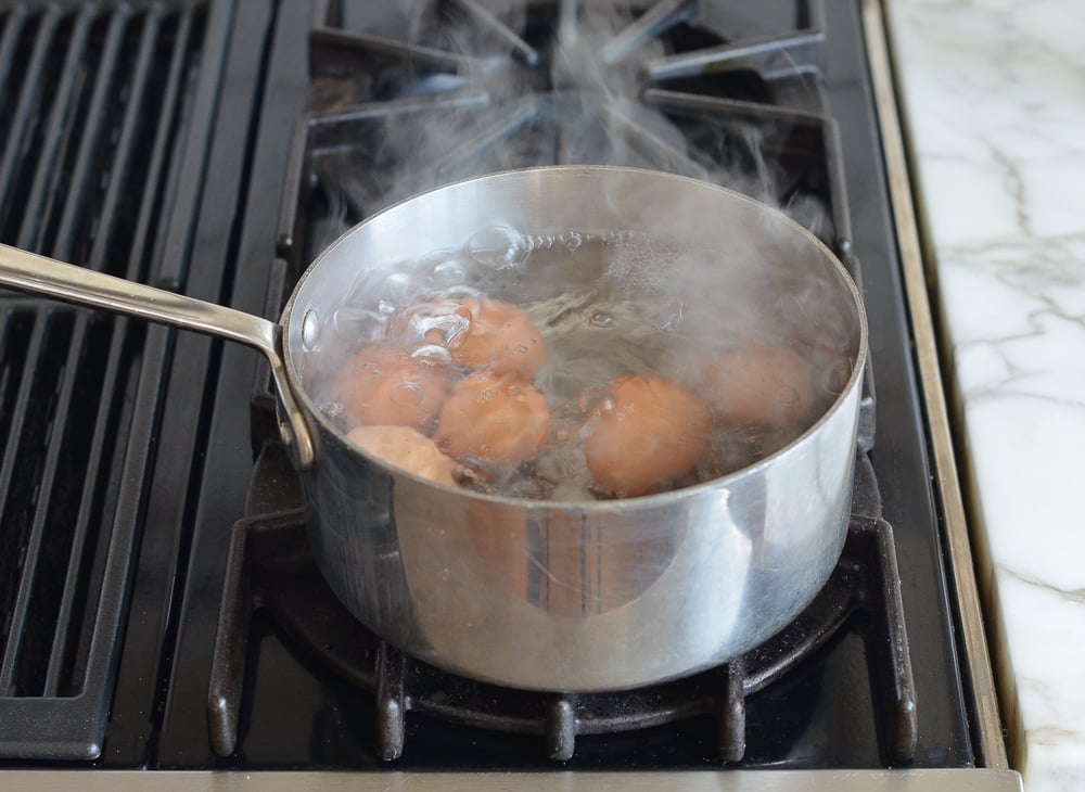 Eggs in boiling water on stove.