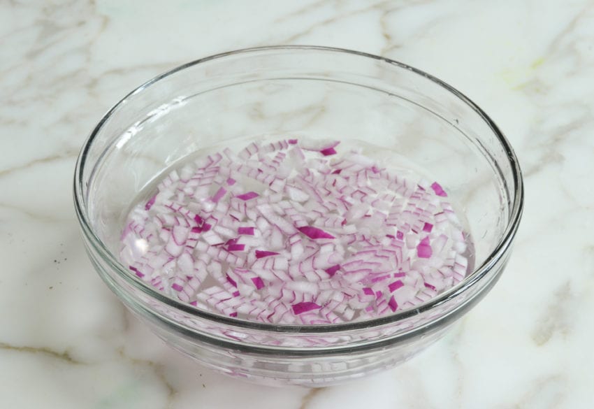 Bowl of red onion in water.