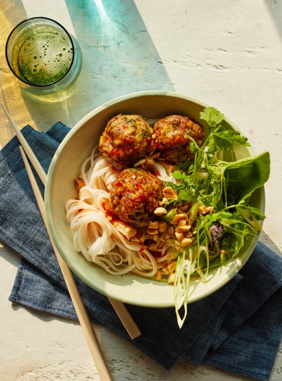 Vietnamese-style meatballs with chili sauce in a bowl over noodles.