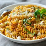 Bowl of pasta with sun-dried tomato pesto and mozzarella pearls.