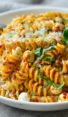 Bowl of pasta with sun-dried tomato pesto and mozzarella pearls.
