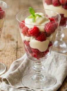 Raspberry and cream parfaits on wooden table