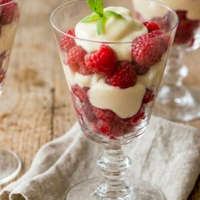 Raspberry and cream parfaits on wooden table