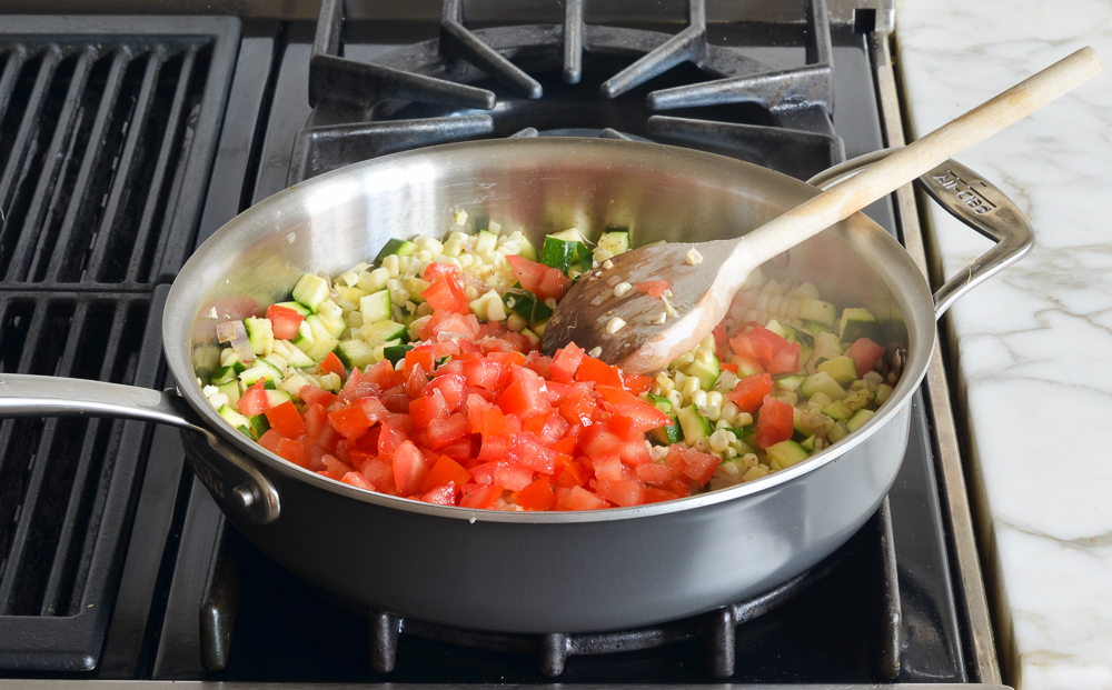 Tomatoes, zucchini, and corn in a skillet.