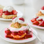 Plates of Strawberry Shortcake on a table with a fork on one.