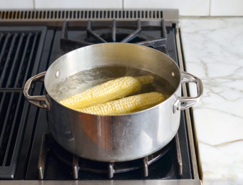 Corn on the cob boiling in a pot.