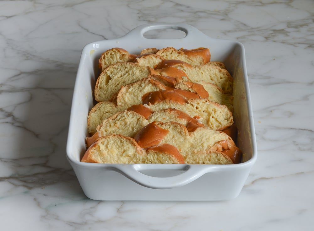 Baking dish full of challah that has been dipped in custard.