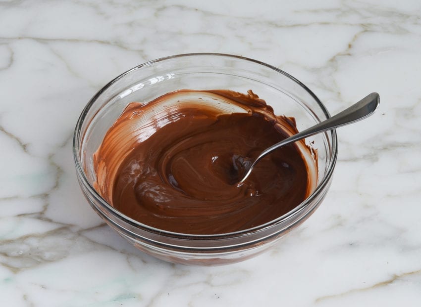 Spoon in a bowl of melted chocolate.