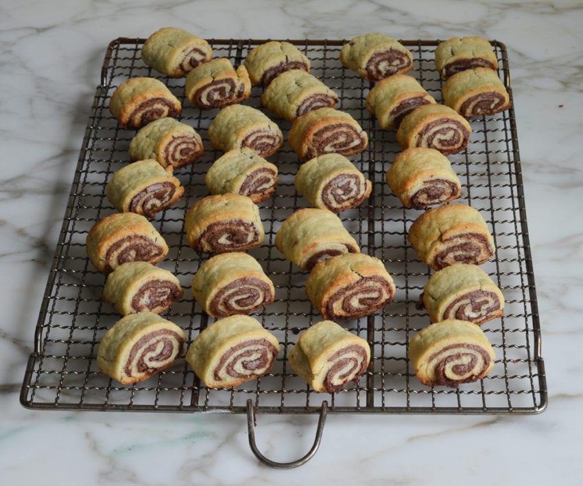Chocolate rugelach on a wire rack.